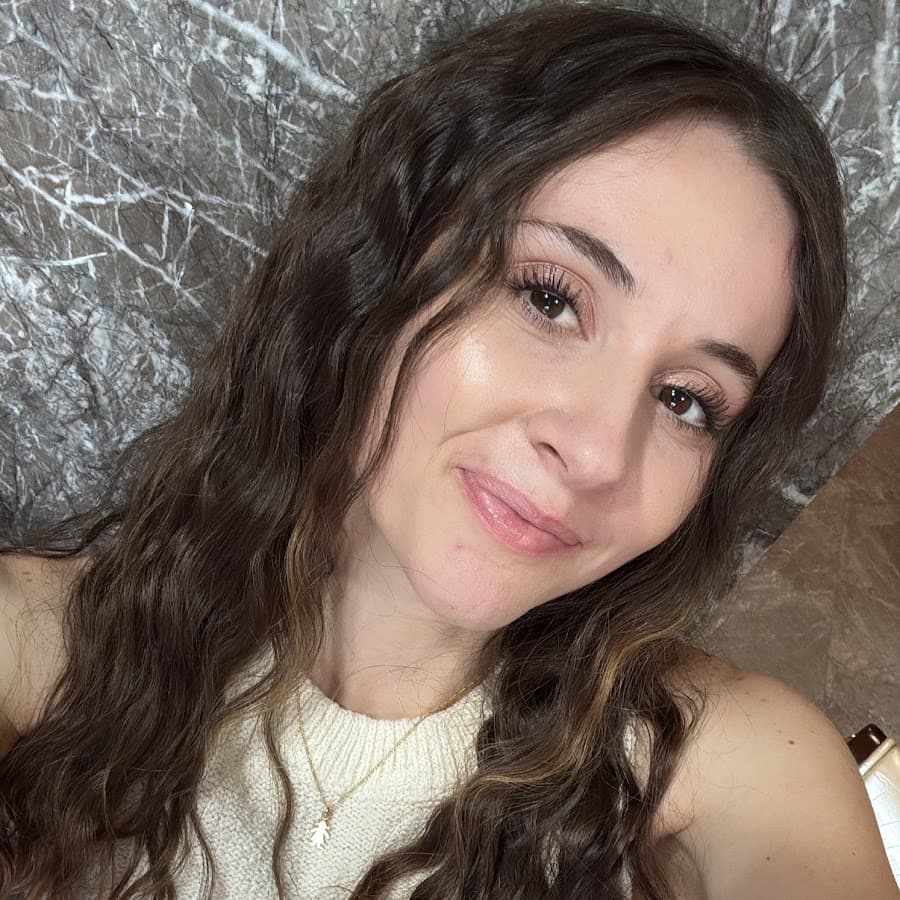 Angela Rose smiling, with long dark wavy hair